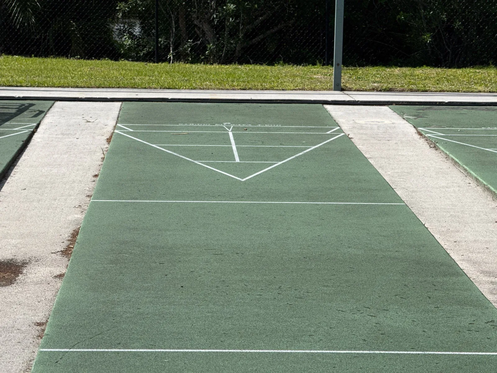 Commercial Painting in Florida Ridge, Florida. Green coated shuffleboard court with crisp white painted lines and scoring triangle.