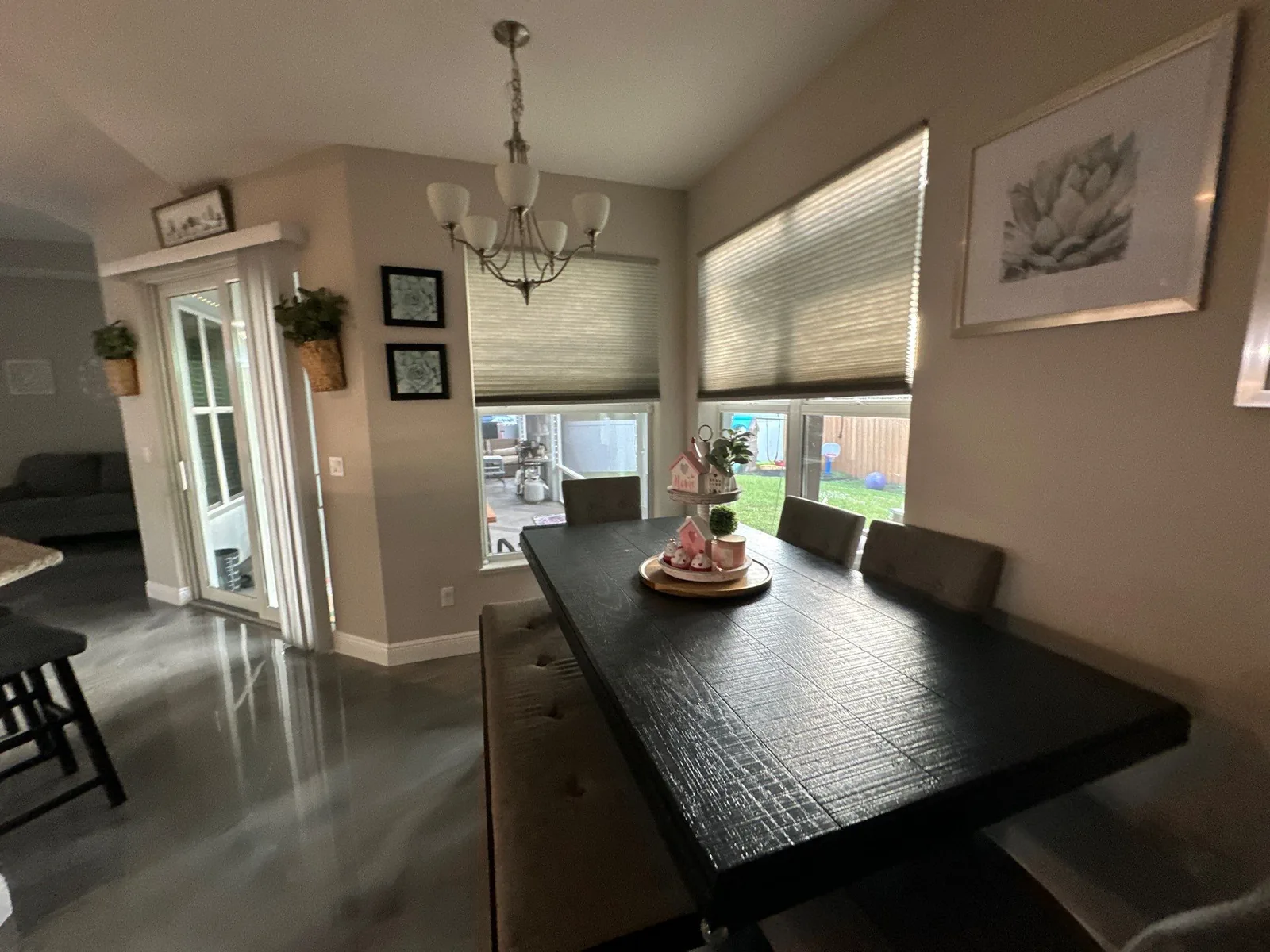Interior Painting in Indian River Estates, Florida. Furnished dining area with painted taupe walls and white trim, dark wood table and chandelier.