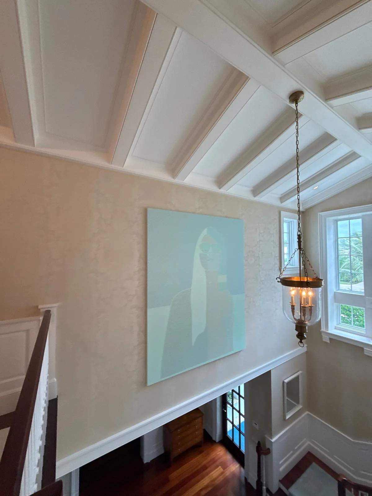 Interior Painting in Palm Beach, Florida. Stair landing with white beamed cathedral ceiling, cream textured walls and a hanging lantern.